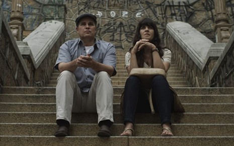 Edson Celulari e Soledad Villamil conversam sentados em uma escada em cena de Teu Mundo Não Cabe Nos Meus Olhos