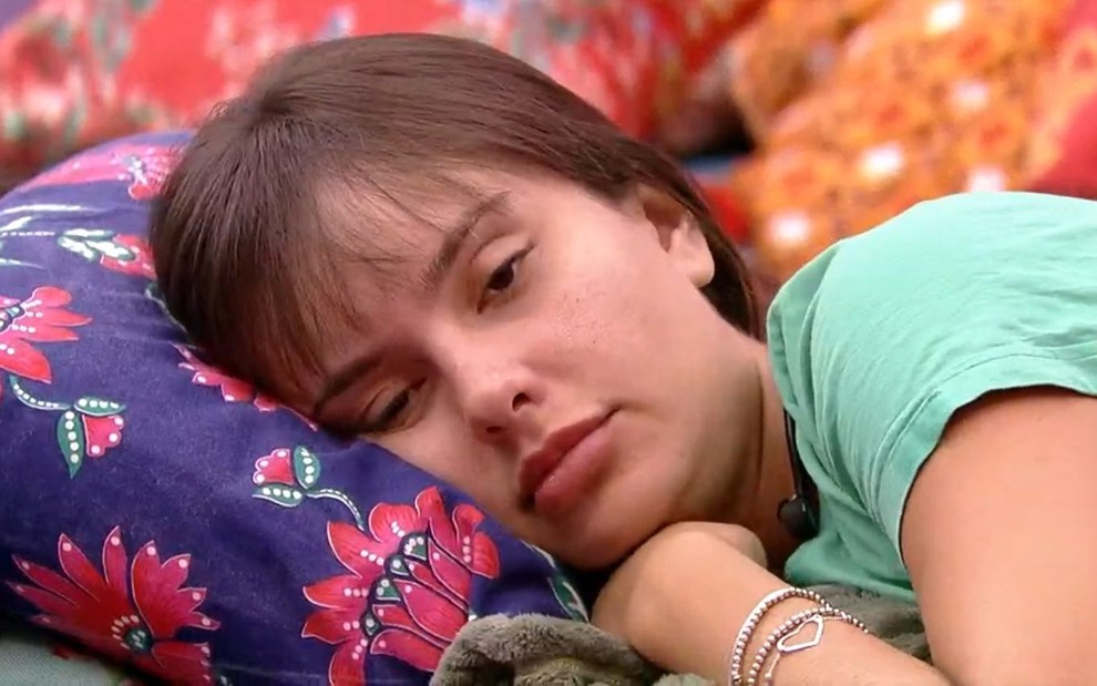 Thaís Braz deitada em cama no quarto do BBB21 durante conversa com Camilla de Lucas, que não está na foto