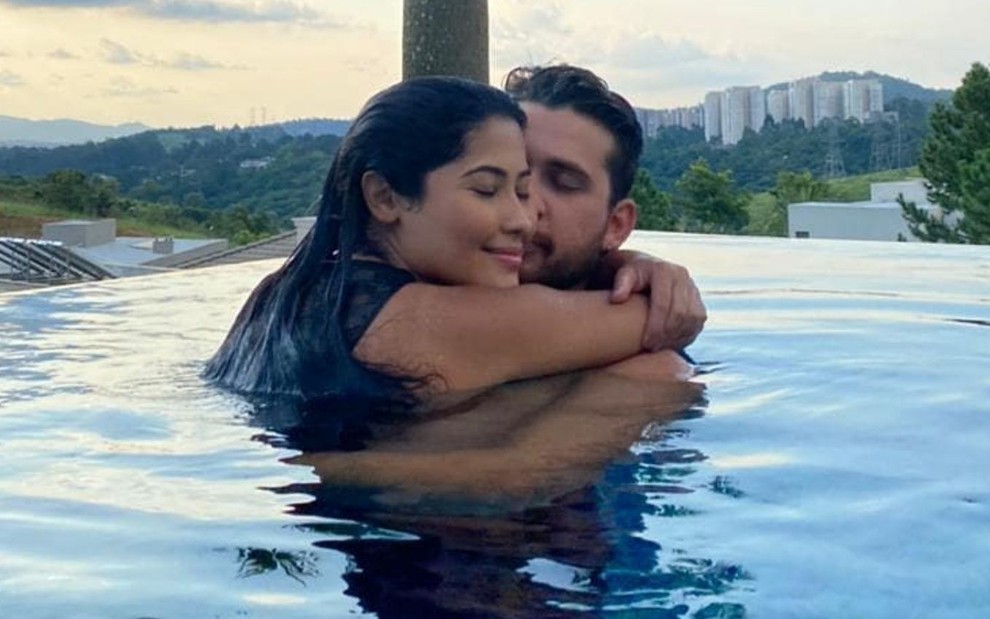Imagem de Thaynara OG e Gustavo Mioto abraçados em piscina