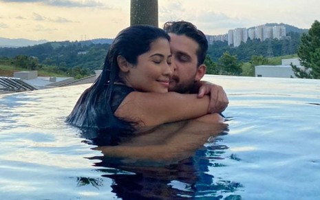 Imagem de Thaynara OG e Gustavo Mioto abraçados em piscina