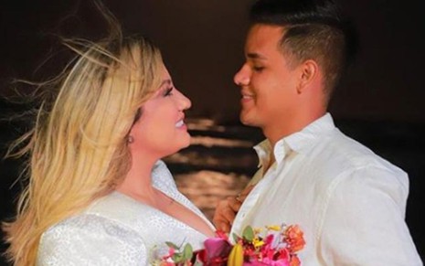 Imagem de Thayse Teixeira e Eduardo Veloso de branco, se casando