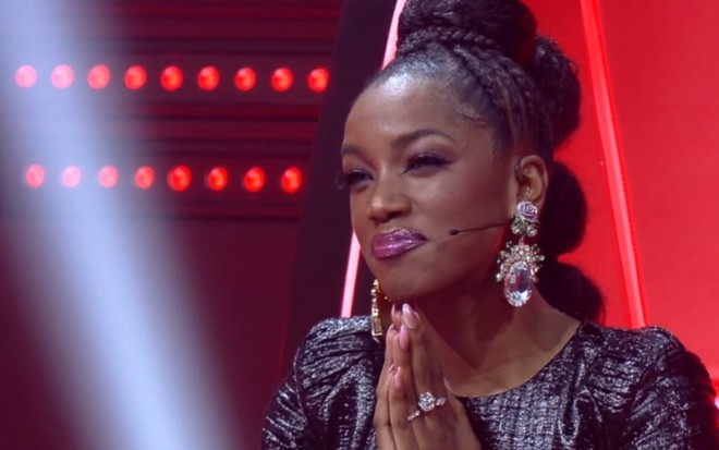 Iza na semifinal do The Voice Brasil 2019, com as mãos juntas e semblante emocionado