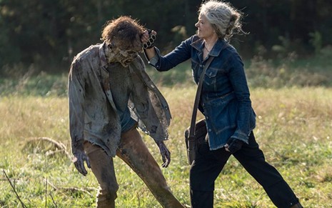 Melissa McBride enfia uma faca na cabeça de um zumbi em cena da 10ª temporada de The Walking Dead