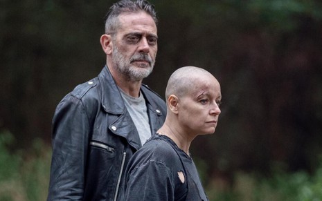 Maltrapilha, a careca Samantha Morton fica na frente de Jeffrey Dean Morgan, com uma jaqueta de couro, em The Walking Dead