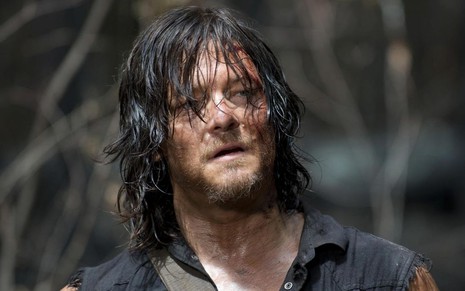 Com cabelo comprido, liso e jogado no rosto, Norman Reedus aparece em cena de The Walking Dead