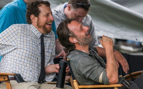 O produtor Scott M. Gimple, de camisa clara, ri junto com Andrew Lincoln nos bastidores de Walking Dead 