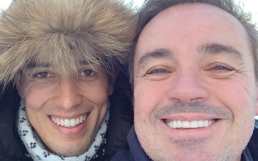 Em um lugar frio, Thiago Salvático e Gugu Liberato sorriem em foto publicada no Instagram