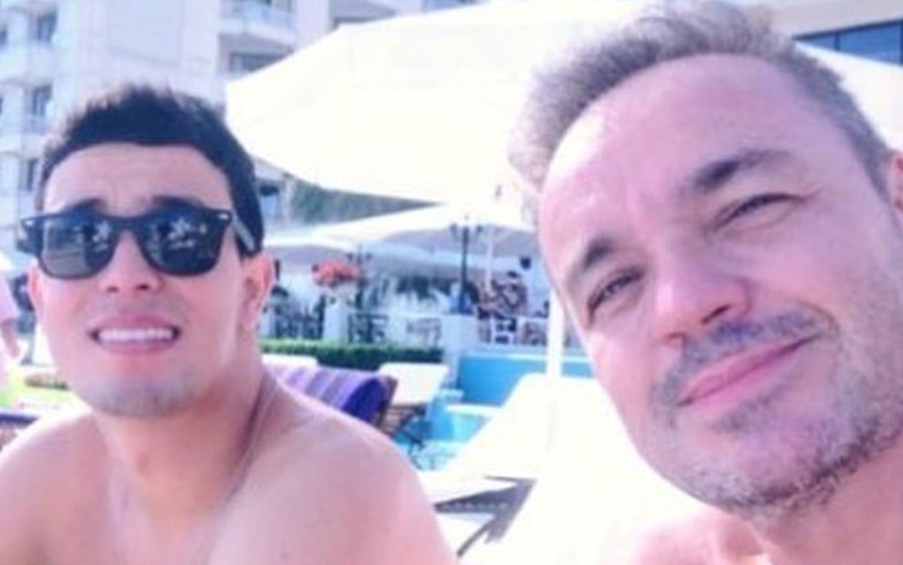 Thiago Salvático ao lado de Gugu Liberato tomando sol sem camisa