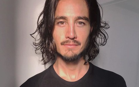Imagem de Tiago Iorc de cabelo solto e camiseta preta