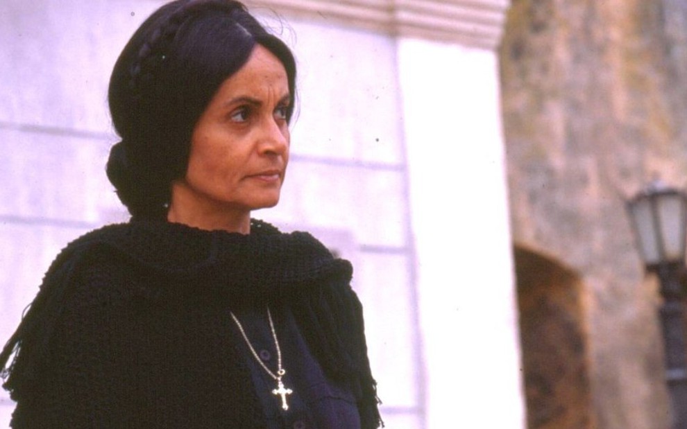 A atriz Joana Fomm caracterizada toda de preto e com expressão séria como Perpétua, sua personagem em Tieta (1989)