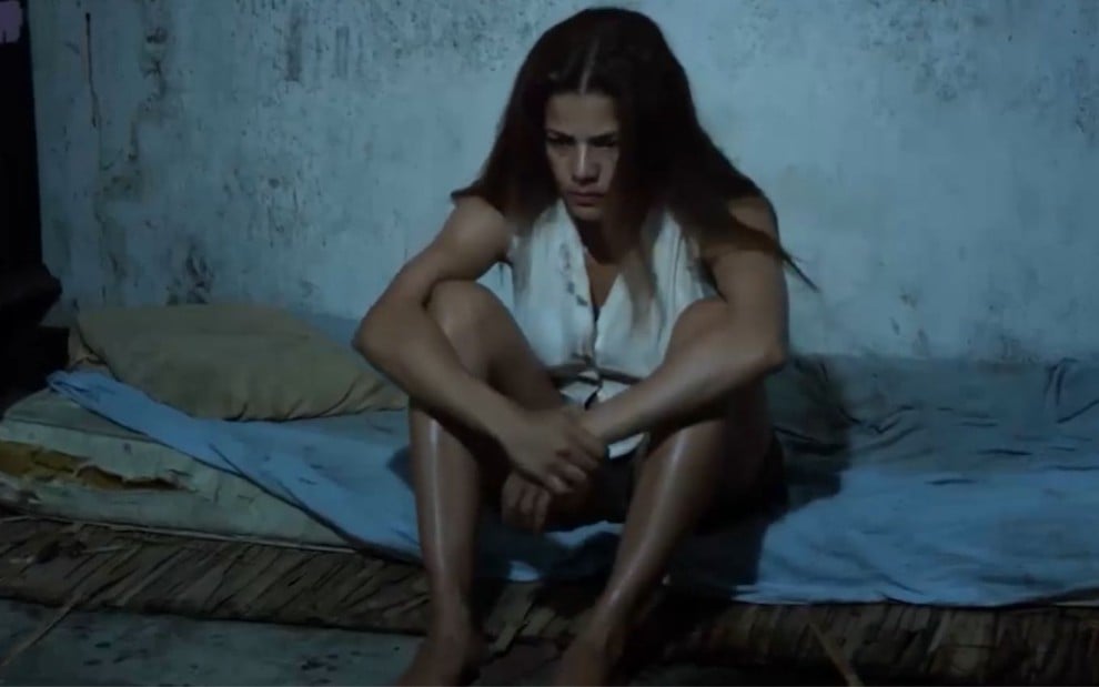 Nívea Stelmann sentada em um colchão em cena do filme Tormento