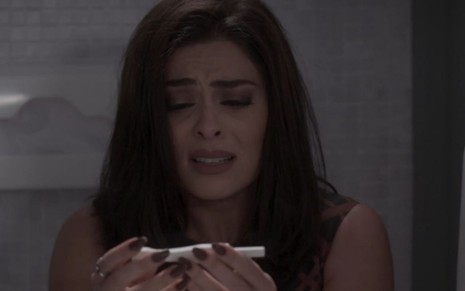 Carolina, personagem de Juliana Paes em Totalmente Demais, chorando com teste de gravidez nas mãos