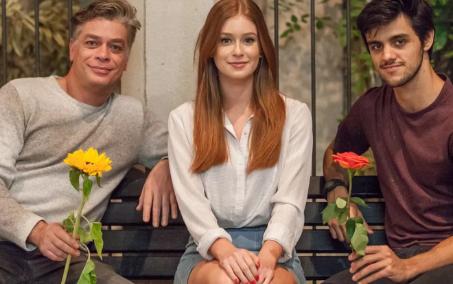 Fábio Assunção e Felipe Simas com flores nas mãos, Marina Ruy Barbosa entre eles, em foto de divulgação de Totalmente Demais