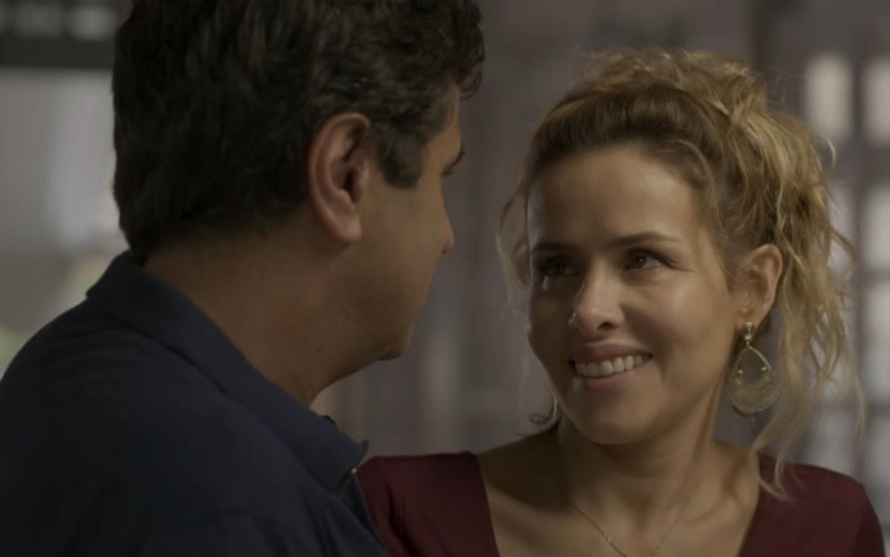 De costas, Hugo (Orã Figueiredo) olha para Gilda (Leona Cavalli), que sorri em cena de Totalmente Demais