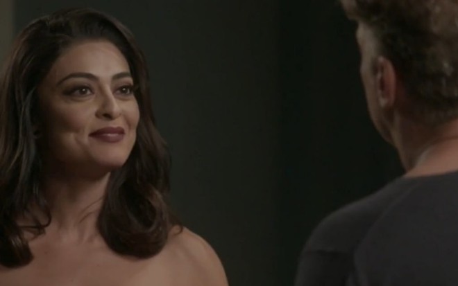 A atriz Juliana Paes (Carolina) sorri e encara Fabio Assunção (Arthur), de costas, em cena de Totalmente Demais