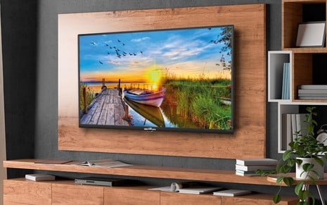 TV Britânia de 55 polegadas pendurada em um painel de madeira em uma sala de alto padrão