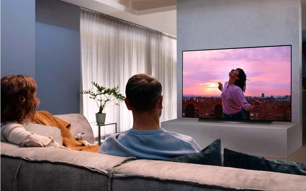 Casal na sala de frente para uma TV OLED