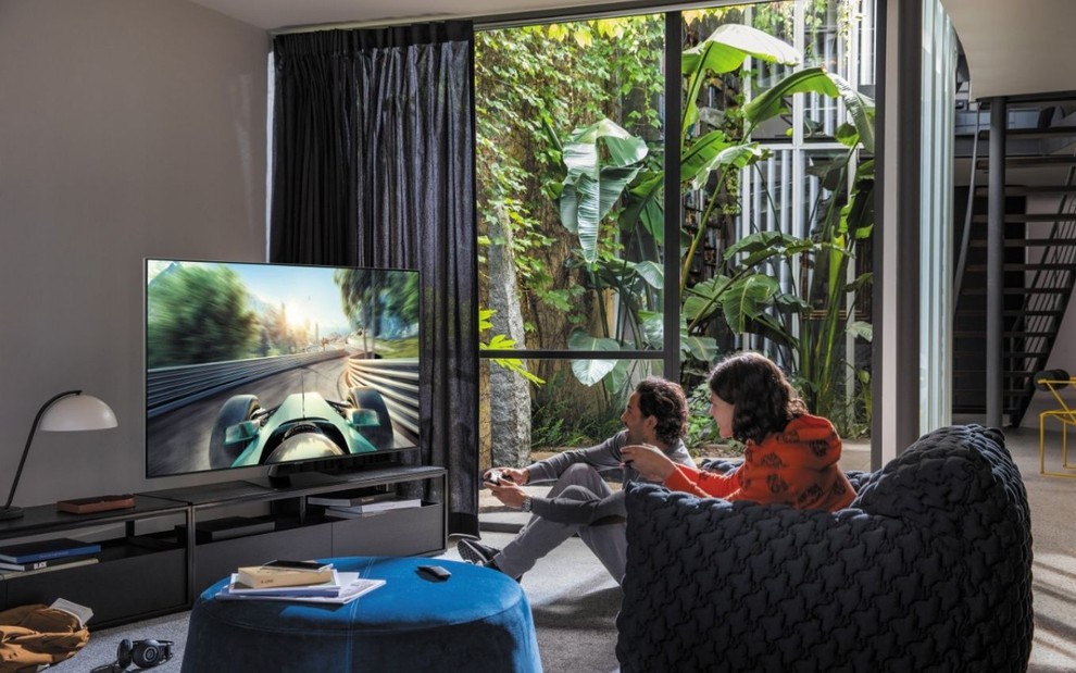 Casal joga videogame na tela de uma TV QLED de 75 polegadas