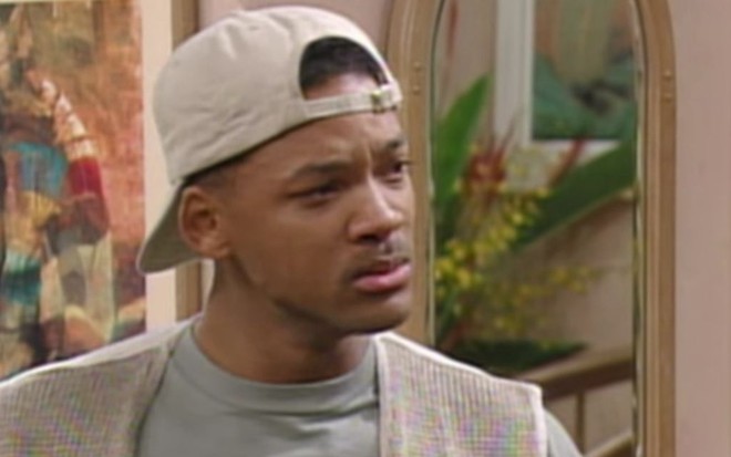 Com um boné bege virado para trás, Will Smith faz cara de choro em cena da série Um Maluco no Pedaço