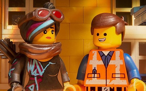 Os bonequinhos amarelos da linha lego Lucy e Emmet se olham em cena do filme Uma Aventura Lego 2 (2019)