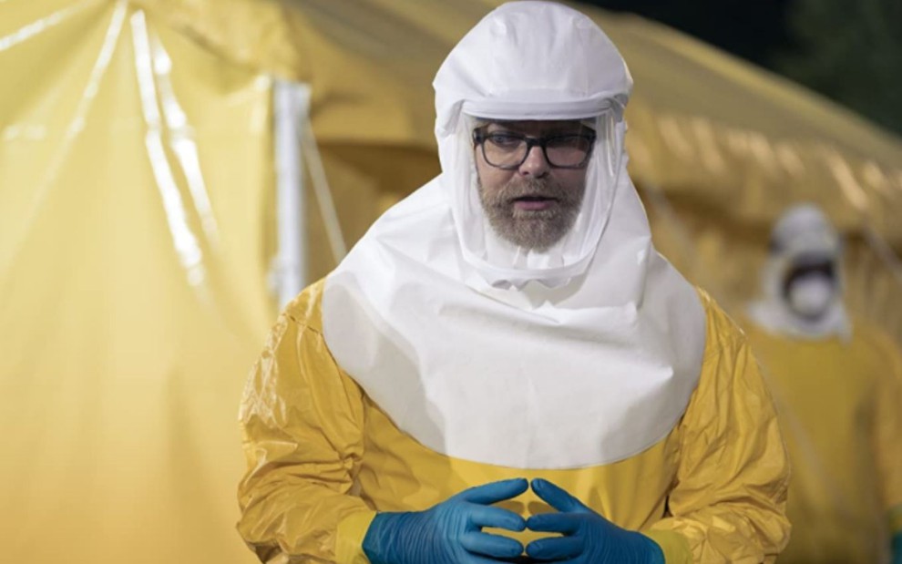 Rainn Wilson com traje antivírus em cena de Utopia