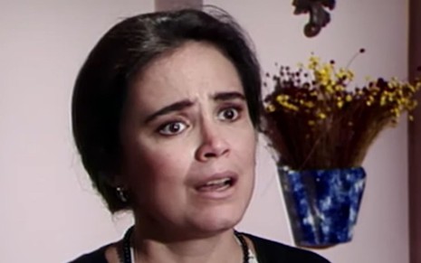 Imagem de Regina Duarte caracterizada como Raquel Accioli em Vale Tudo, com cabelo amarrado e roupas de dona de casa