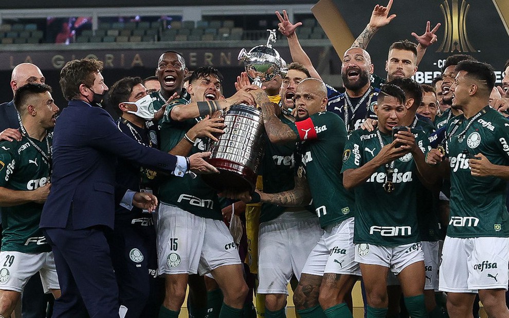 Jogadores e equipe técnica do Palmeiras levantando a taça da vitória da Libertadores