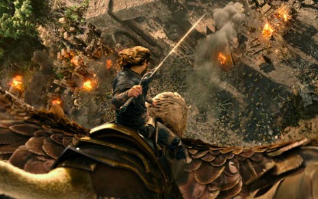 Um homem em cima de um dragão, com uma espada na mão, indo em direção a um lugar destruído e com fogo