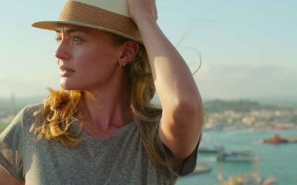 De chapéu, a personagem Zoe Walker (Laura Haddock) admira a ilha de Ibiza em cena de White Lines