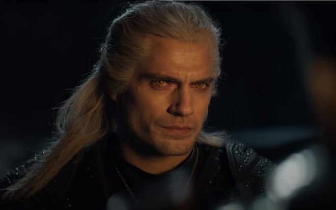 Ator Henry Cavill encara a câmera no escuro em The Witcher