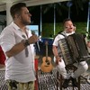 Os músicos Bruno e Marrone em uma live feita em 9 de abril; Bruno canta de pé enquanto Marrone está sentada com sanfona