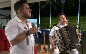 Os músicos Bruno e Marrone em uma live feita em 9 de abril; Bruno canta de pé enquanto Marrone está sentada com sanfona