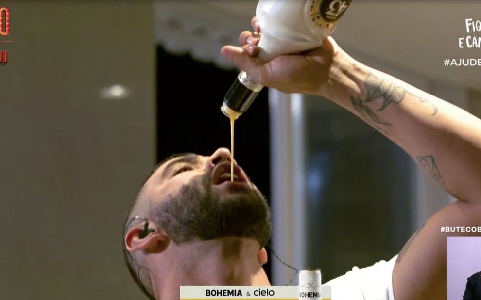 O cantor sertanejo Gusttavo Lima virando uma garrafa de bebida alcoólica na boca durante live no YouTube, em 11 de abril 