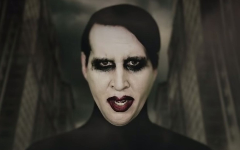 O cantor Marilyn Manson no clipe We Are Chaos, disponível no YouTube, em que ele aparece com maquiagem gótica, vestido de preto, em cenário sombrio