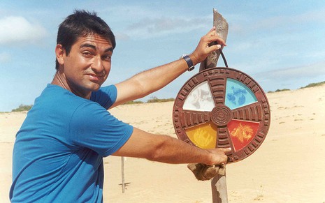 Zeca Camargo no ano 2000 segurando uma mandala na praia em que foi gravado o No Limite