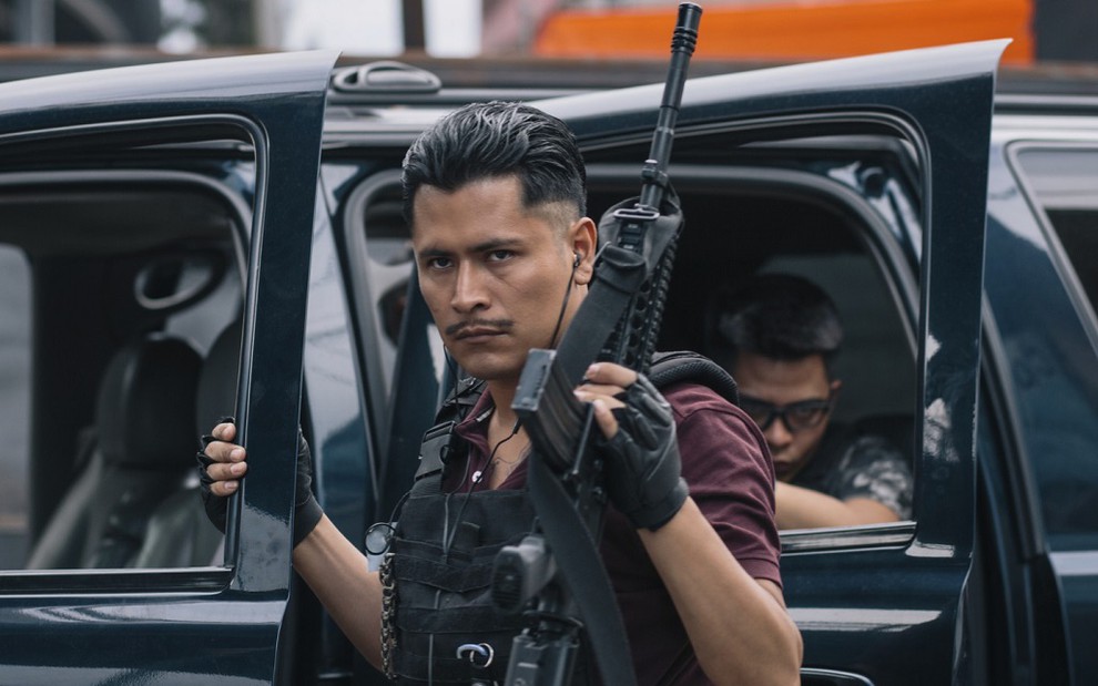 O ator Harold Torres em imagem da minissérie ZeroZeroZero; armas de grosso calibre marcam presença