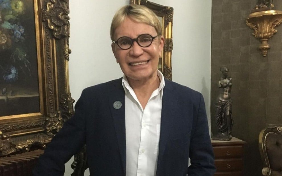 Zezinho Correa de terno, sorrindo e usando óculos