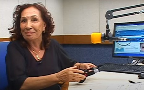 Zora Yonara na rádio com o fone de ouvido na mão