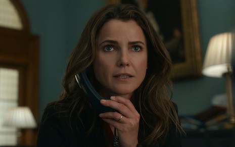 Keri Russell fala ao telefone em cena da série A Diplomata