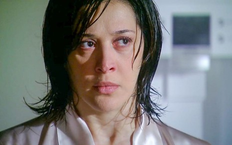 A atriz Claudia Raia como Donatela em A Favorita; ela está de cabelo molhado, olhando para o lado com cara de apreensiva
