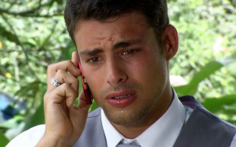 O ator Cauã Reymond como Halley em A Favorita; ele está olhando para baixo enquanto fala no celular com cara de preocupado
