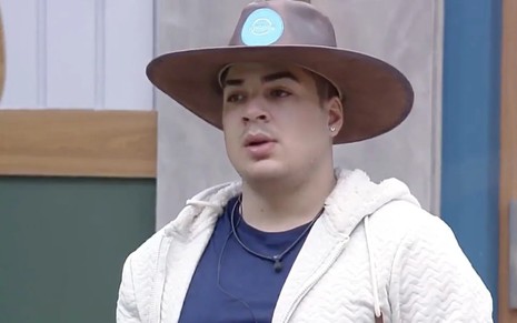Lucas Santos com chapéu, jaqueta branca e blusa azul em A Fazenda 14