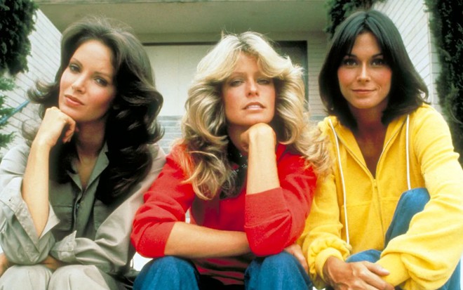 Jaclyn Smith, Farrah Fawcett e Kate Jackson estão sentadas em uma varanda em foto promocional de As Panteras