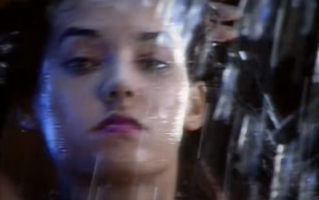 A atriz Mônica Carvalho na abertura de Mulheres de Areia, com gotas de água em sua frente, com expressão séria