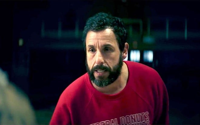 Adam Sandler com uma barba preta e uma blusa vermelha durante cena de Arremessando Alto, seu próximo filme na Netflix