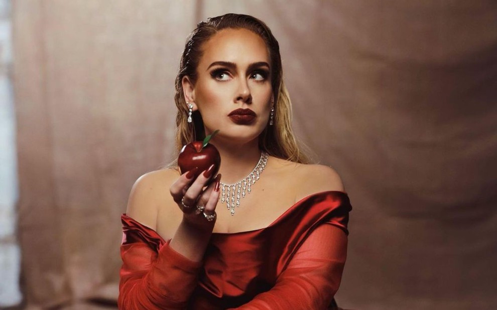 Adele segurando um maçã