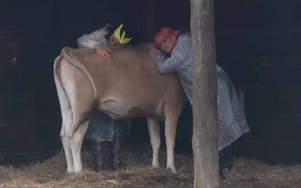 Imagem de Aline Mineiro (à esq.) e Valentina Francavilla abraçando a vaca de A Fazenda 13