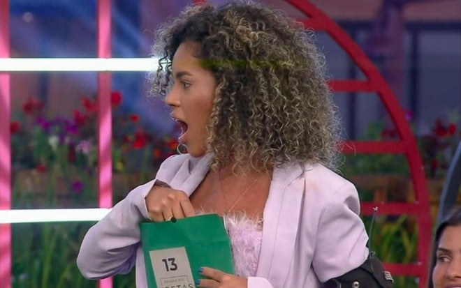 Imagem de Sthefane Matos abrindo um envelope de prêmio durante a lavação de roupa suja em A Fazenda 13