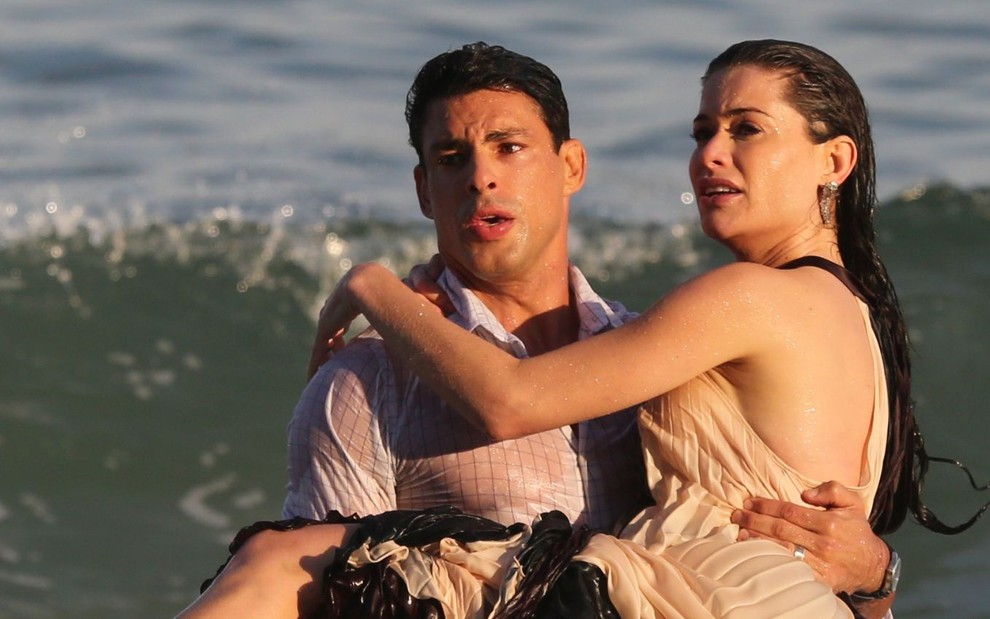 Os atores Cauã Reymond e Alinne Moraes saem do mar em gravação da novela Um Lugar ao Sol na Praia de Grumari no Rio de Janeiro