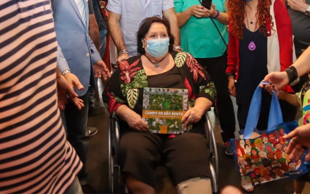 A mãe de Paulo Gustavo, Déa Lúcia em evento em Niterói (RJ) nesta segunda (22), em que aparece em uma cadeira de rodas